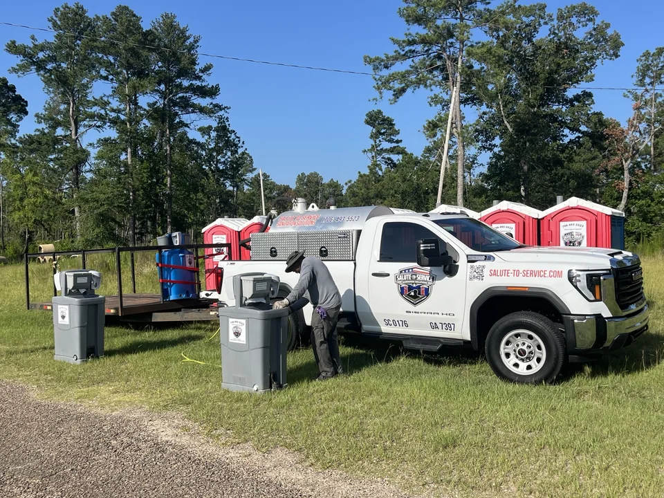 An S2S crew member, company truck and sanitation equipment in the field.